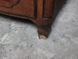 a cat that is sitting on the floor next to a dresser