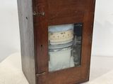 a small wooden box with a clock inside of it