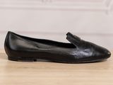 a black loafer shoe with a buckle on the side
