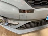 a close up of the front of a car with a sticker on it