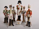 five figurines of different sizes and colors of soldiers