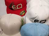 several different colored hats are lined up on a white surface