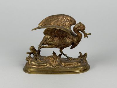 bronze statue of a bird with a bird on it ' s back