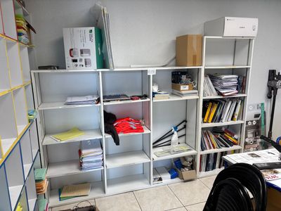 a room with a desk, shelves, and a chair in it