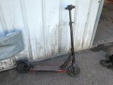 un scooter posé par terre à côté d'un immeuble