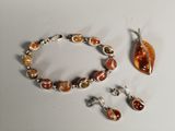 bracelet and earring set with orange glass beads on a white surface