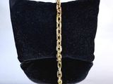 bracelet avec une chaîne en or présenté dans un sac en velours noir