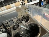 a sink with a bunch of silver spoons and utensils in it