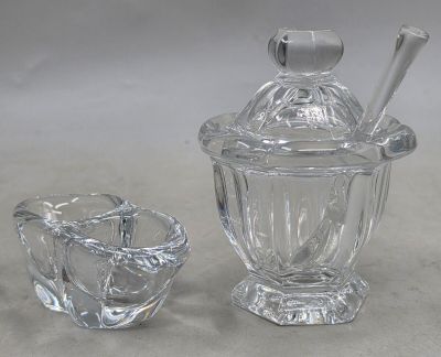 un bocal en verre avec une cuillère et un saladier en verre contenant une cuillère