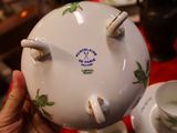 a person holding a tea pot and a cup on a table