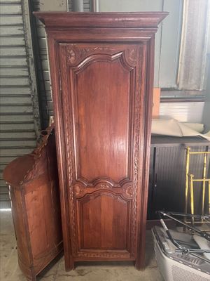 une armoire en bois posée à côté d'une chaise dans une pièce