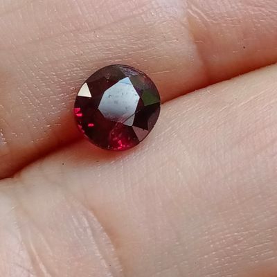 un gros plan sur la main d'une personne tenant un diamant rouge et blanc