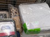 a pile of mattresses and other items in a shopping cart
