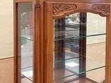 a wooden display case with glass shelves in a room