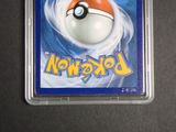 a pokemon card in a plastic holder on a table