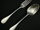 deux cuillères et une fourchette posées sur une surface noire