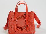 un sac à main orange orné d'un motif représentant des rayons de soleil sur le devant