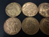 six different british coins sitting on top of a black surface