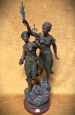 statue en bronze représentant deux femmes tenant un oiseau et une branche