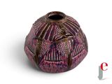 a purple vase with a bird on it on a white surface