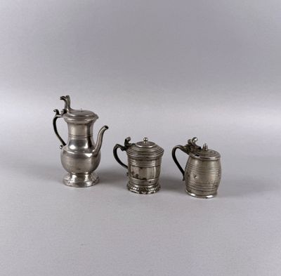 three silverplated teapots and a coffee pot on a table