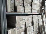 boxes of electronic equipment are stacked on a shelf in a warehouse
