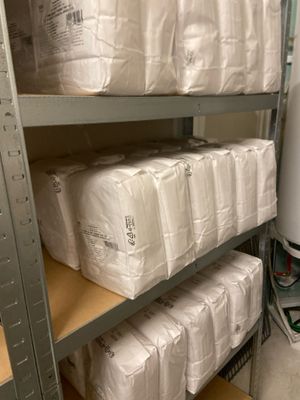 de nombreux rouleaux de papier toilette sur les étagères de la salle de bains