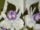 a close up of a purple and white flower on a green and white scarf