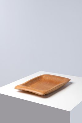 the square wooden plate is sitting on a white table