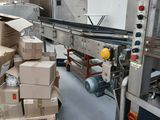 Les cartons sont empilés sur un tapis roulant dans un entrepôt
