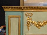a fireplace with a gold leaf decoration on the mantle