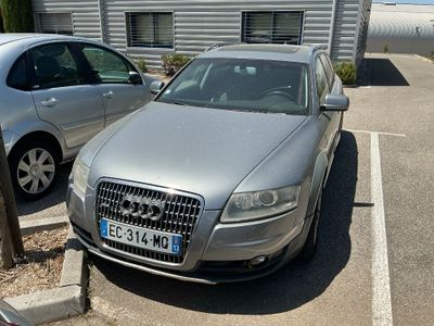a silver car parked in a parking lot next to a silver car