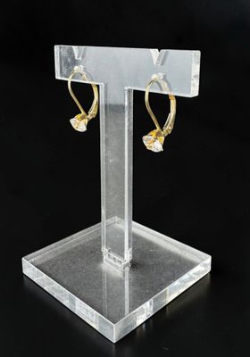 présentoir en acrylique transparent sur lequel sont disposées deux paires de boucles d'oreilles