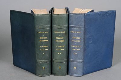 three books are stacked on top of each other on a gray surface