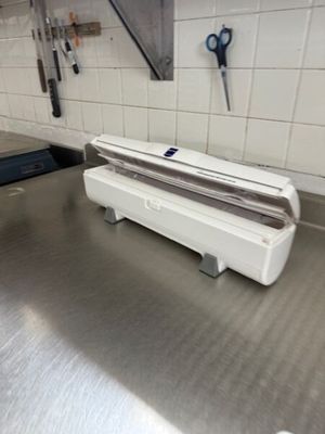 plan de travail en acier inoxydable dans une cuisine professionnelle, avec des ciseaux accrochés au mur