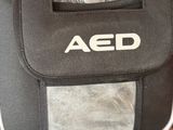 a person holding an aed bag in their hand