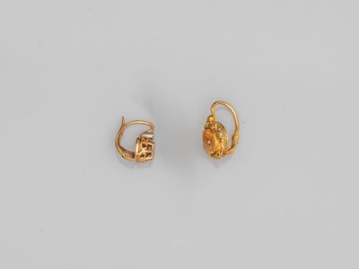 une image d'une paire de boucles d'oreilles en or sur fond blanc