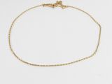 a gold chain ankle bracelet with a tiny heart charm