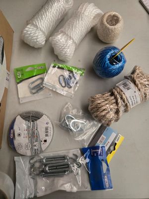une table sur laquelle se trouvent un tas de pelotes de laine, des ciseaux et d'autres objets