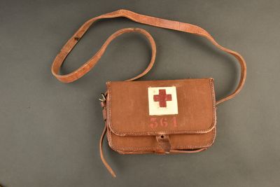 leather first aid bag with red cross on it on a table
