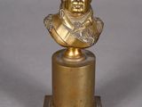 buste en bronze d'un homme posé sur un socle, avec une chaîne autour du cou