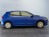 the blue car is parked on the concrete floor in the room