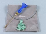 un petit sac orné d'une fleur bleue et d'un pompon vert