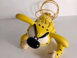 a yellow and black dog toy on a white surface
