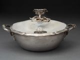 une cocotte ancienne en métal argenté, avec un couvercle et des poignées