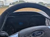 a steering wheel and dashboard of a car on the road