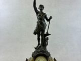 a bronze statue of a man holding a bird and a clock