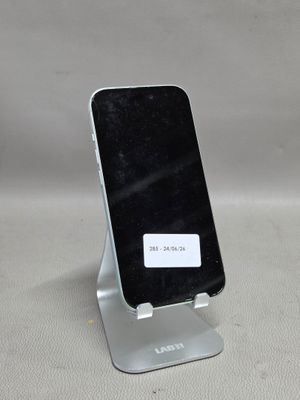 un téléphone portable posé sur un support sur une table