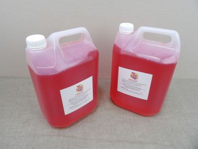 deux gallons de liquide rouge posés l'un à côté de l'autre sur une table