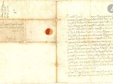 un vieux document marqué d'un point rouge, posé sur une feuille de papier